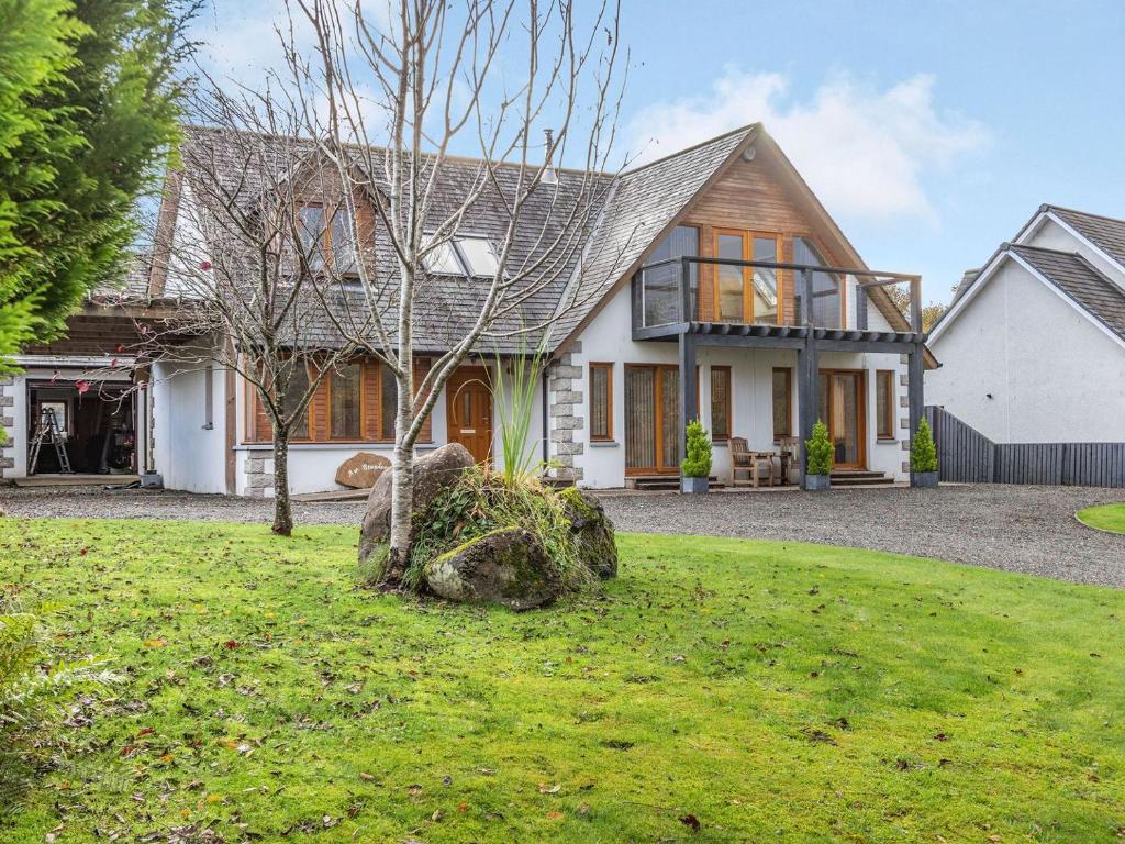 a house with a tree in the yard at Am Bruadar in Dalmally