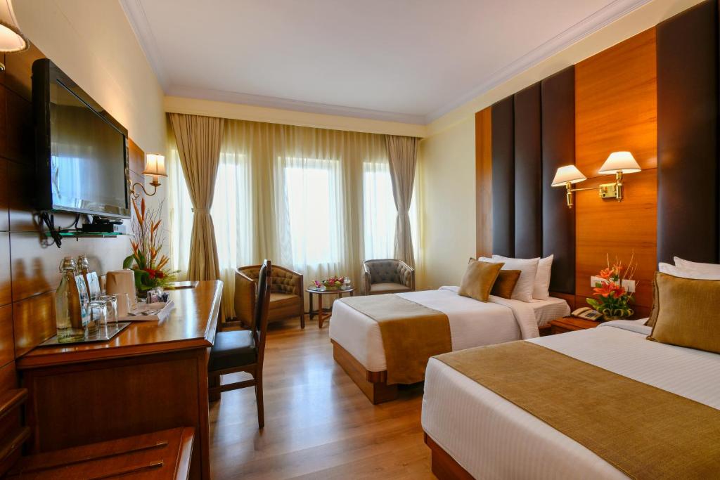 Postel nebo postele na pokoji v ubytování Peerless Hotel Kolkata