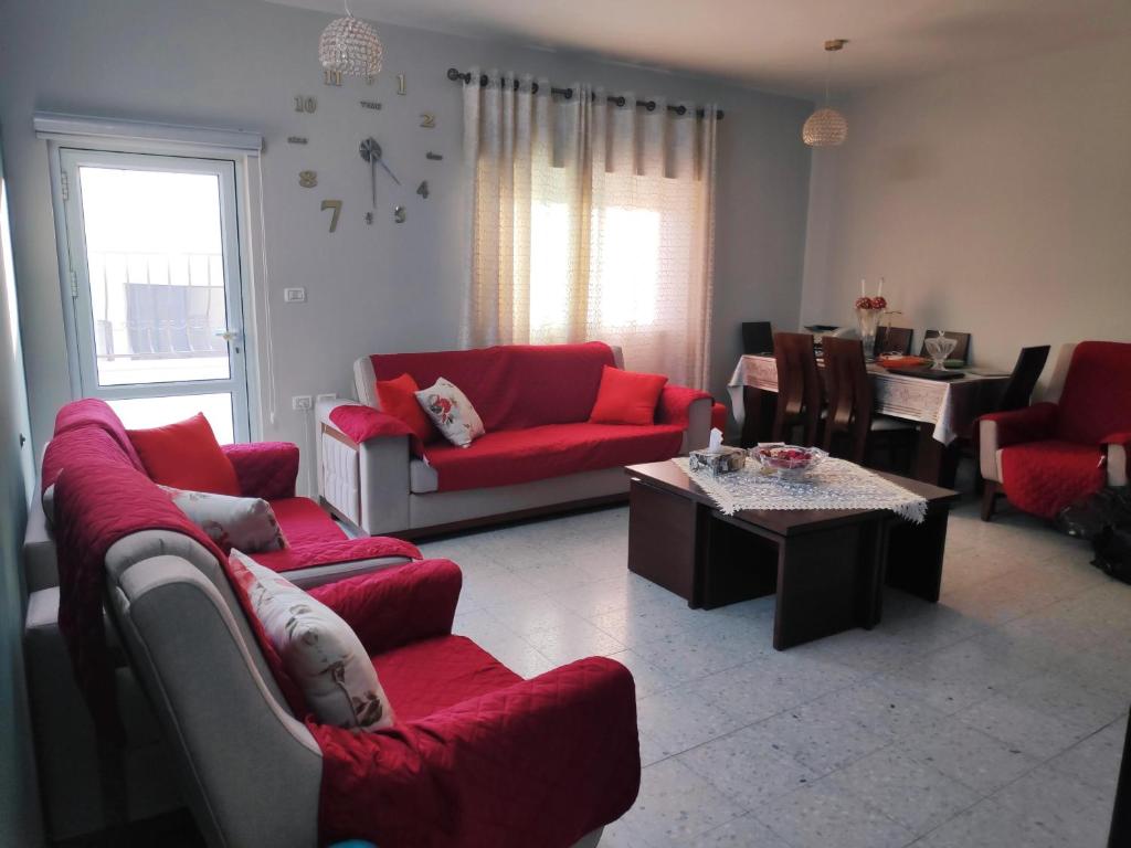 uma sala de estar com sofás vermelhos e uma mesa em Fully Furnished Apartment in Bethlehem Center em Belém