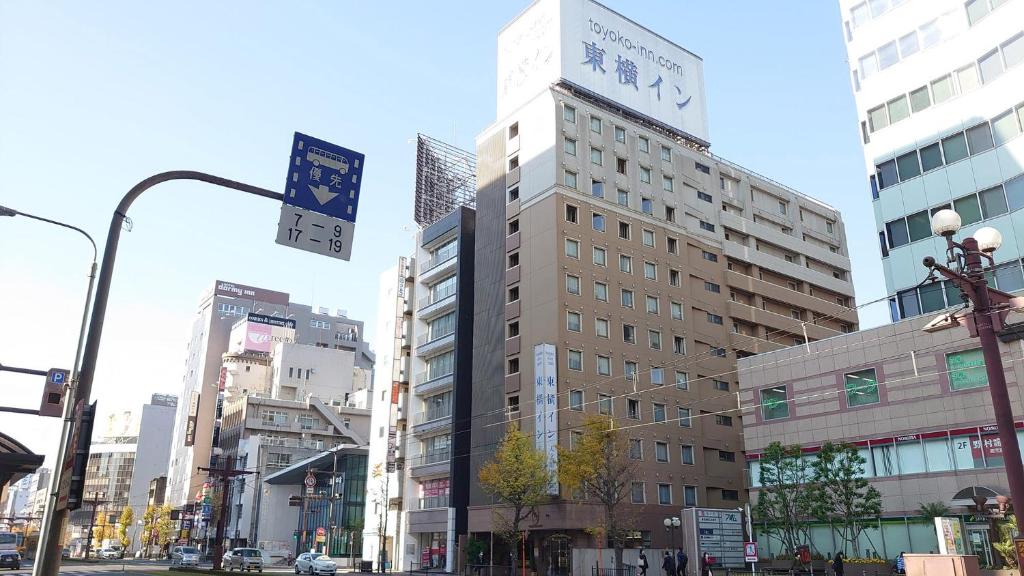 ein hohes Gebäude mit einer Uhr drauf in einer Stadt in der Unterkunft Toyoko Inn Kagoshima Temmonkan No 2 in Kagoshima