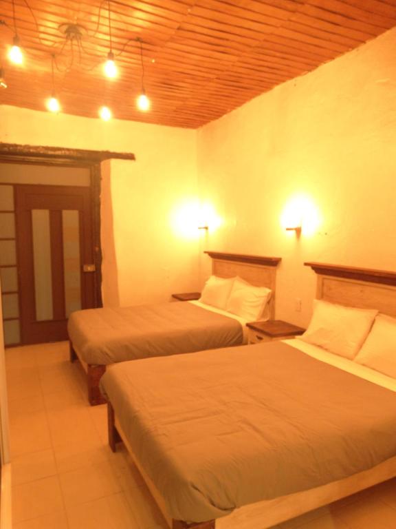 a hotel room with two beds and two lamps at Cuarto Casa Alebrije in Valle de Bravo