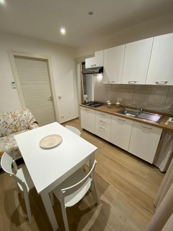 a kitchen with a table and a white table and chairs at Dimora Garibaldi Apartment & Room in Agrigento