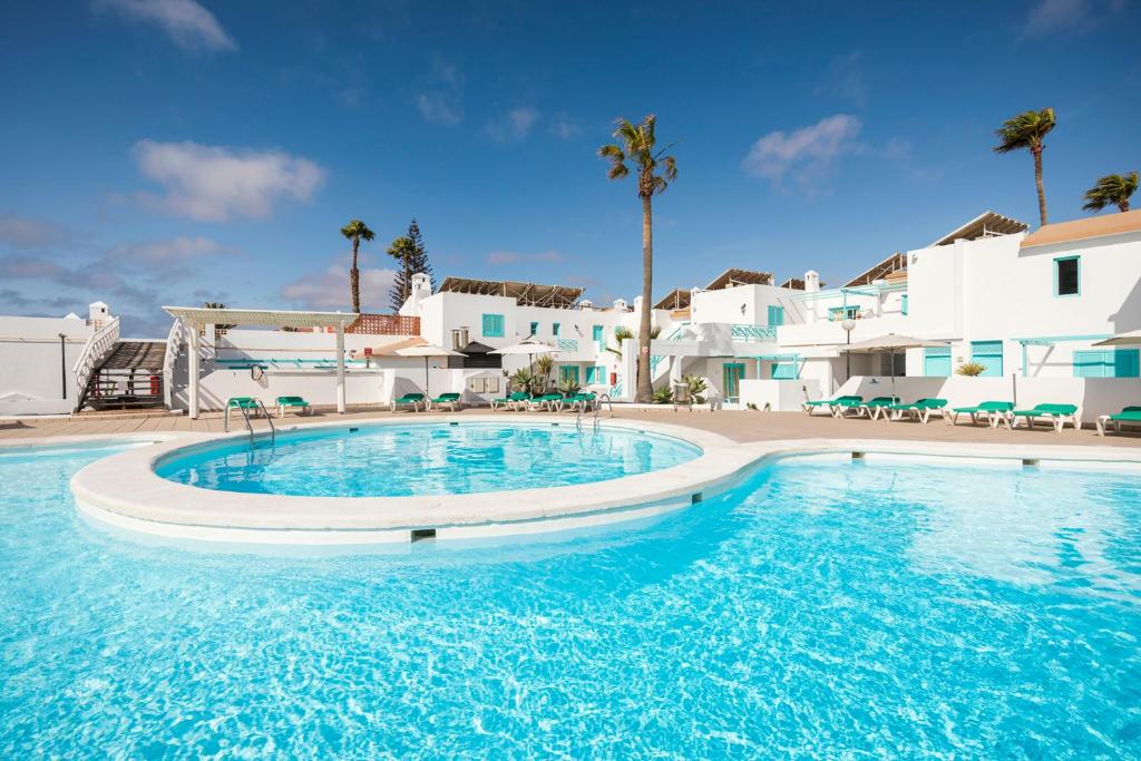 une grande piscine d'eau bleue devant des bâtiments blancs dans l'établissement Smy Tahona Fuerteventura, à Caleta de Fuste