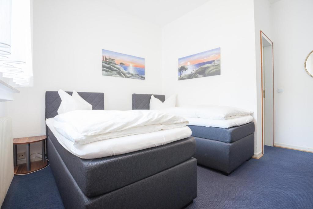 two twin beds in a room with a mirror at TM Hotel Dortmund Airport in Holzwickede