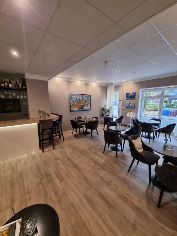 a waiting room with tables and chairs in a restaurant at Hotel Diamant in Wedel