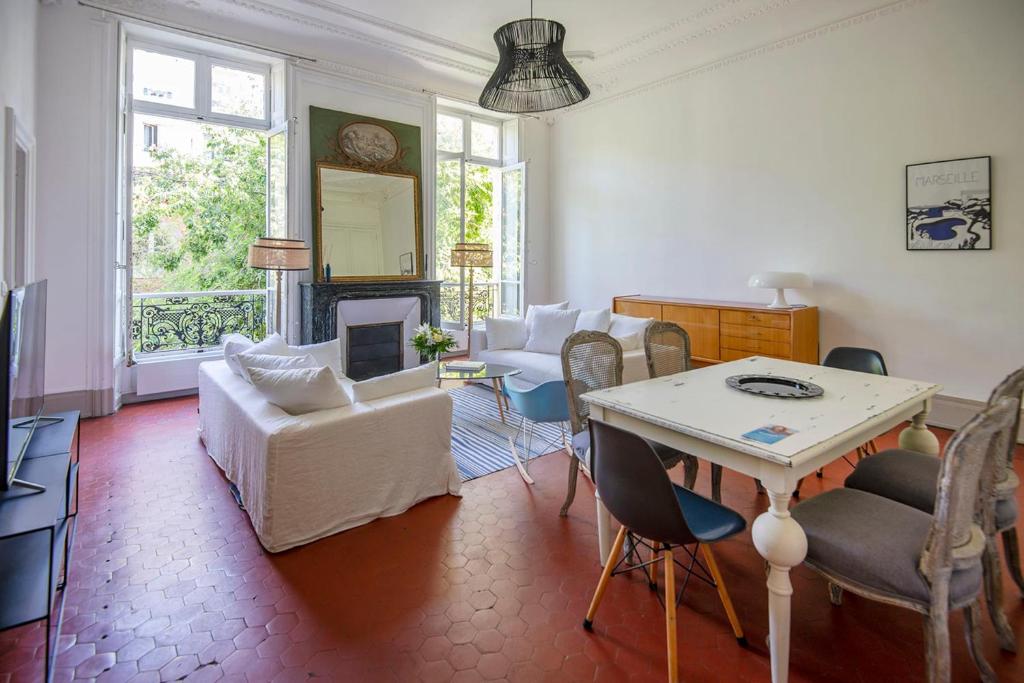 een woonkamer met een tafel en een open haard bij 80m with garden view near the Old Port in Marseille