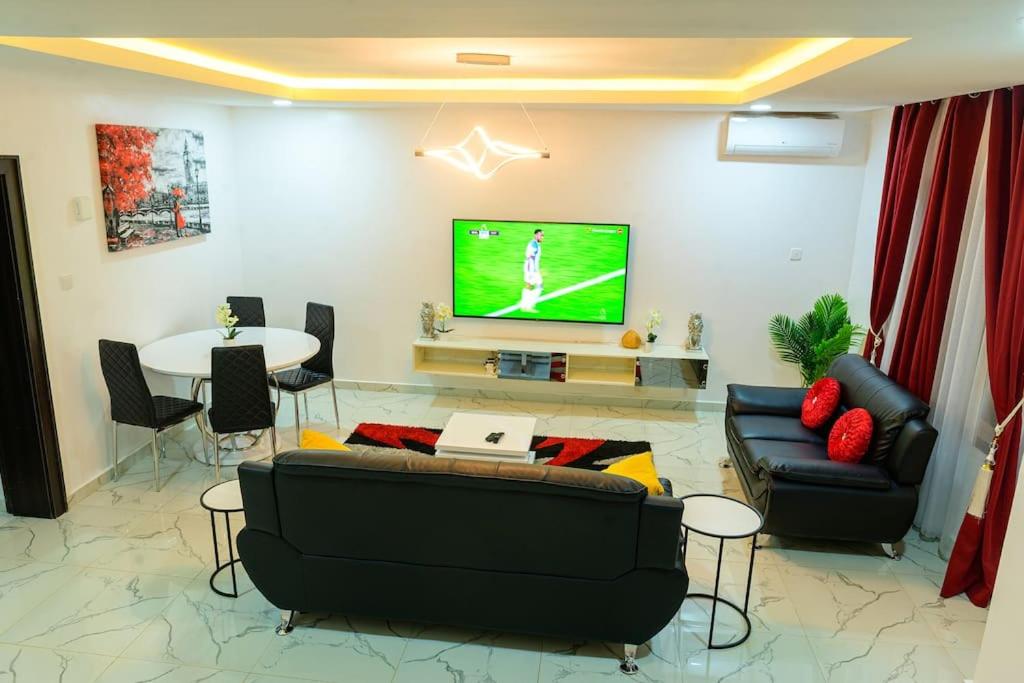 a living room with a tv and a couch and a table at Cc & Cg Homes Luxury 4-Beds Apart Abuja-24Hrs Power in Abuja