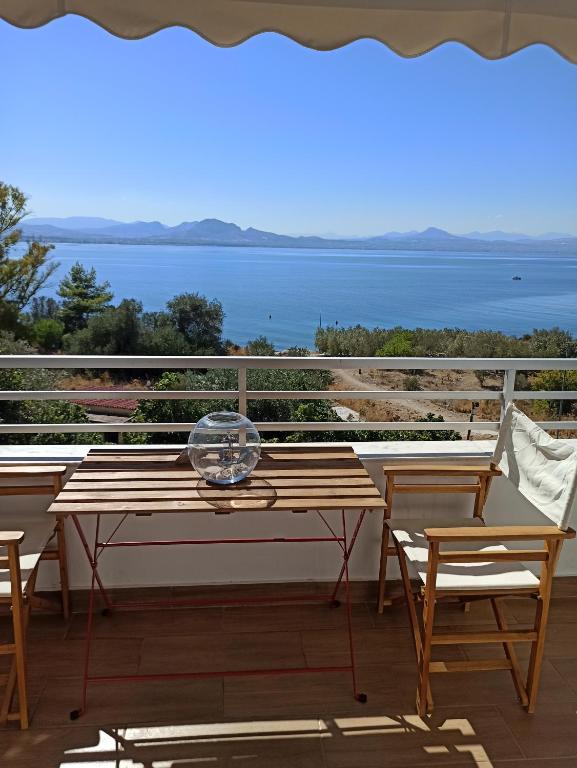 einen Tisch und Stühle auf einem Balkon mit Meerblick in der Unterkunft Atlas_Endless Blue Apartment in Loutraki