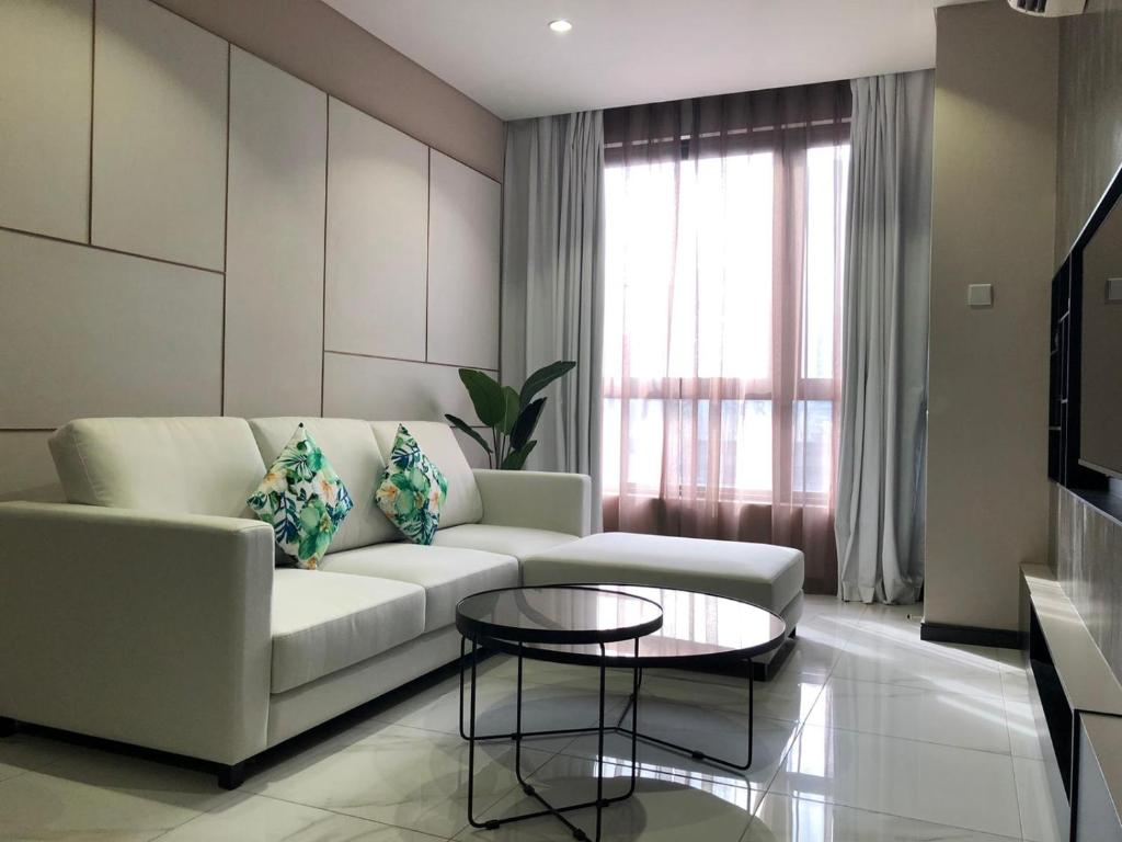8 Kia Peng Residences by StayHere في كوالالمبور: غرفة معيشة مع أريكة وطاولة