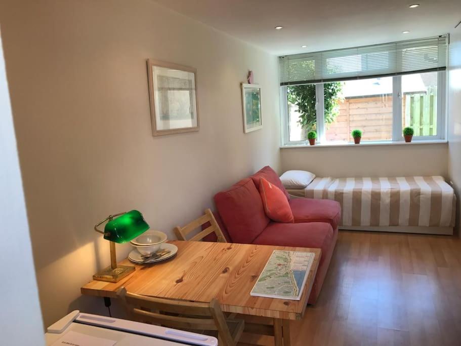 un soggiorno con divano rosso e tavolo di Apartment with own entrance & terrace on West Hill a Hastings