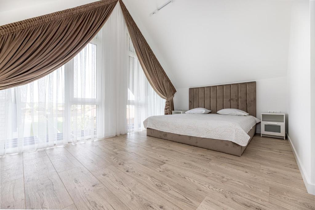 a bedroom with a bed and a large window at Sea House 2N in Palanga