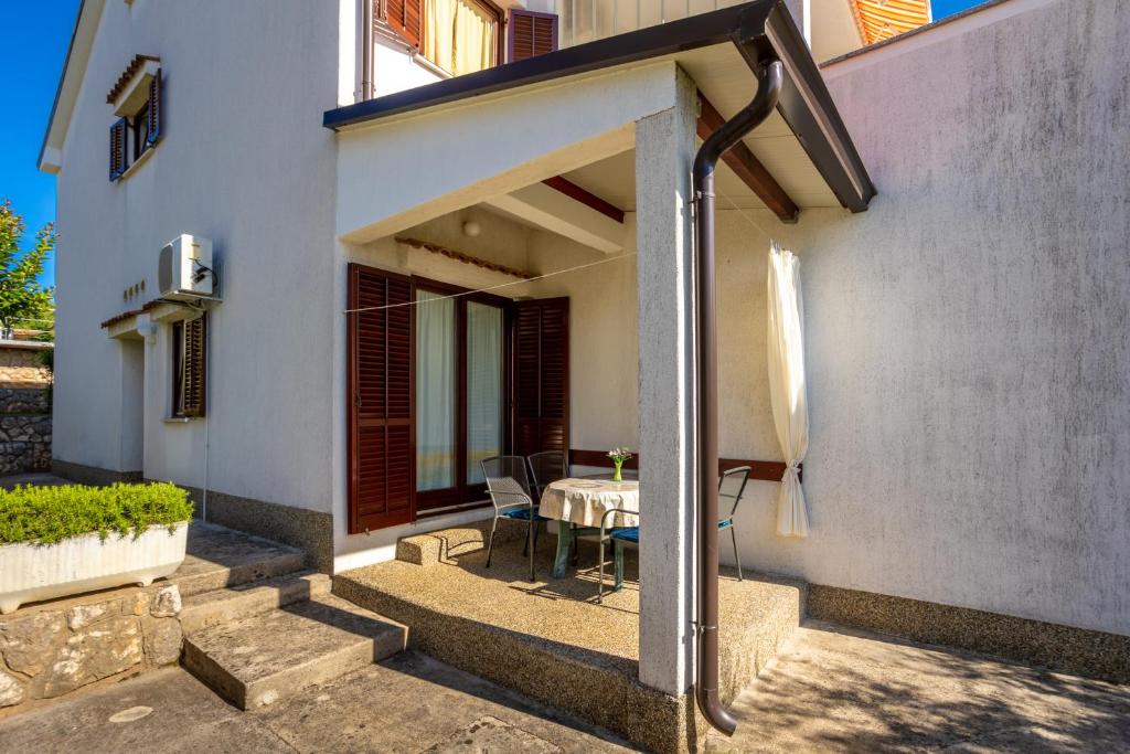 a patio of a house with a table and chairs at Apartments Belavic in Njivice