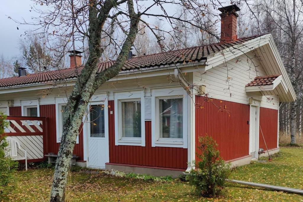 a small red and white house with a tree at Parviainen-Helppoa yöpymistä in Soini