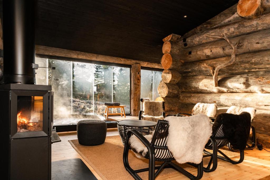 a living room with a fireplace in a log cabin at Keloruka 15 luxury lodge, 5 ensuite bedrooms, 250 m2, jacuzzi, 2 x ski pass in Ruka