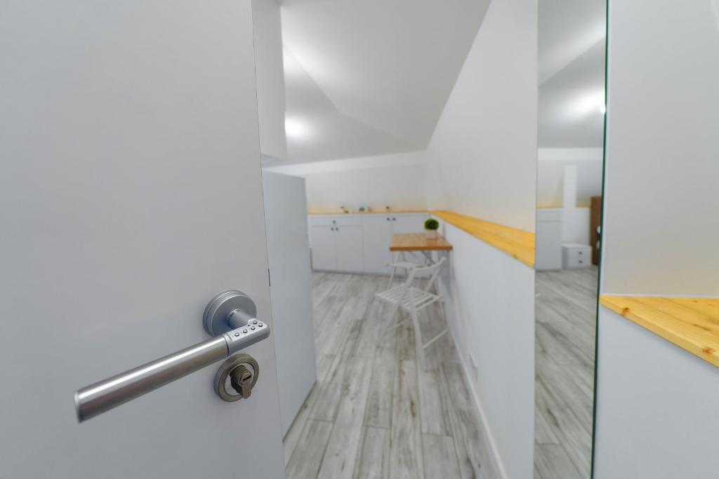 una puerta a una cocina con paredes blancas y suelo de madera en Bella House, en Craiova
