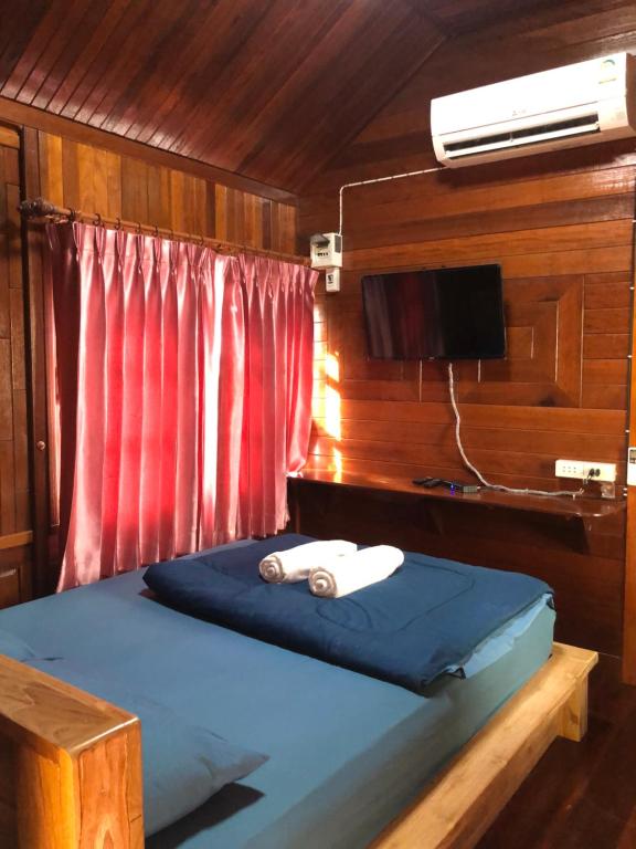 sypialnia z łóżkiem i telewizorem w łodzi w obiekcie KOB SUK RESORT k7 , k10 w mieście Sichon