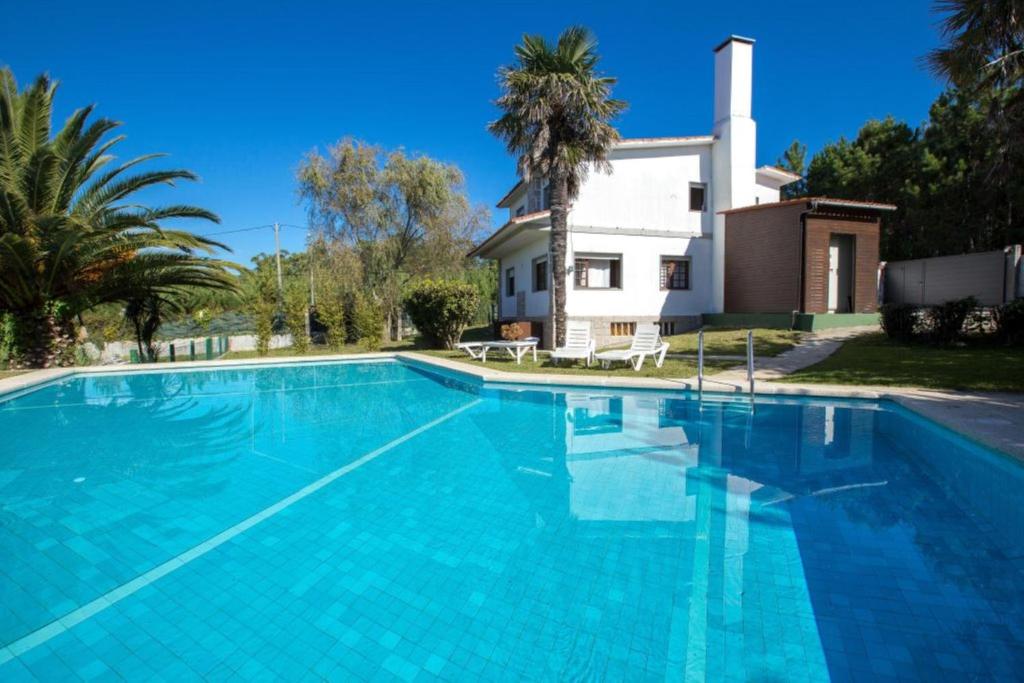 a large swimming pool in front of a house at House - 3 Bedrooms with Pool WiFi and Sea views - 7428 in Portonovo