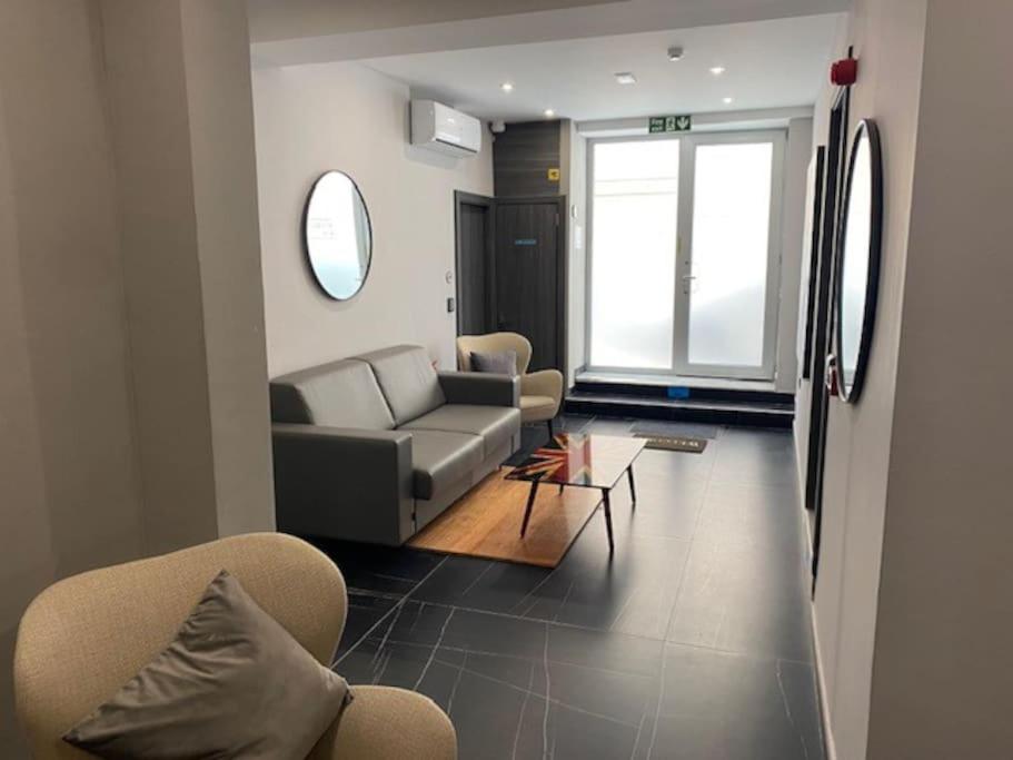 uma sala de estar com um sofá e cadeiras e uma janela em Lovely Modern Large Spacious Home with 7BR & WIFI by 360 Estates em Msida