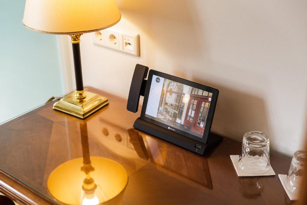 a desk with a lamp and a television on it at Bohemian Hotel in Regensburg