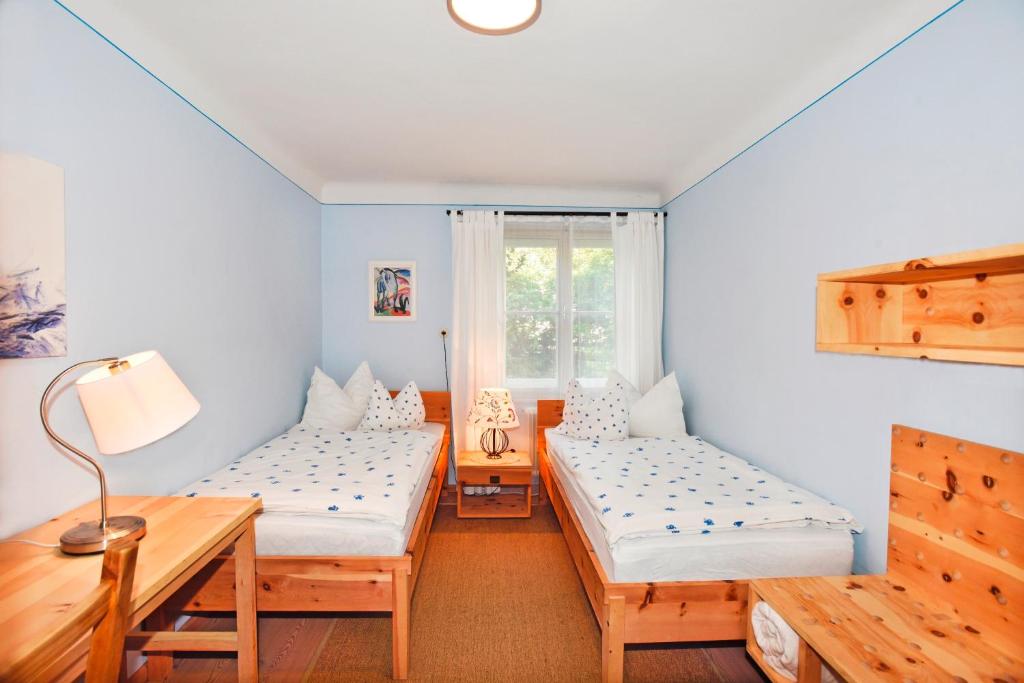 ラートシュタットにあるLandhaus Mooslechnerのベッド2台、テーブル、窓が備わる客室です。