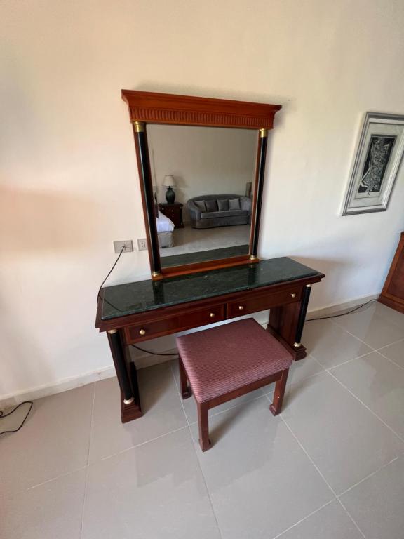 einen Schminktisch mit einem Spiegel und einem Stuhl in der Unterkunft Palm resort 2B in Sharm El Sheikh