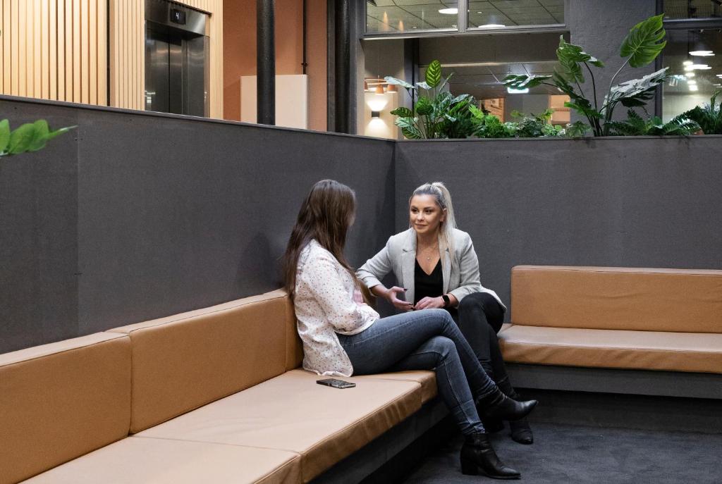 two women sitting on a bench in a building at Citybox Oslo in Oslo