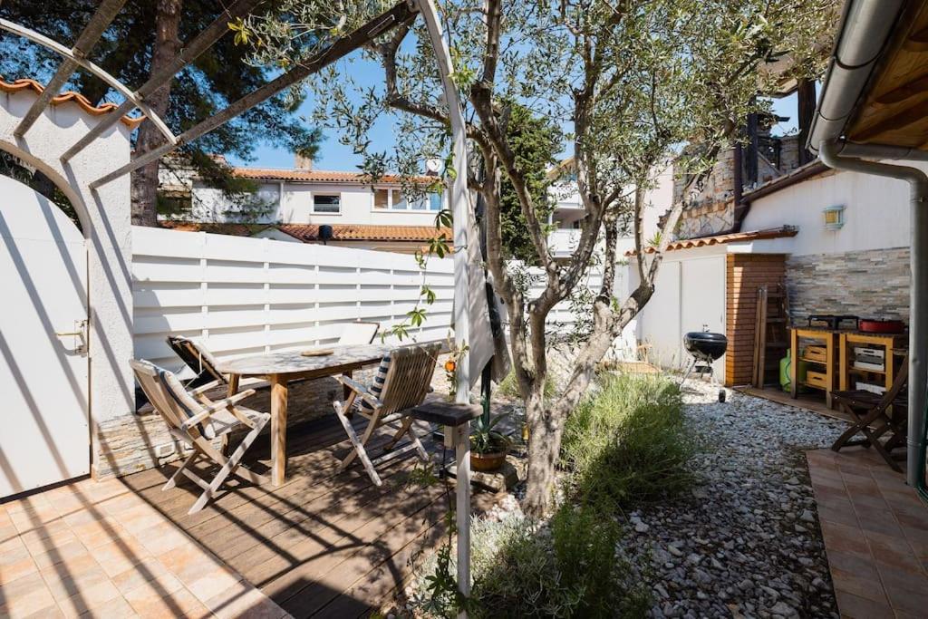 eine Terrasse mit einem Holztisch und Stühlen neben einem Baum in der Unterkunft Pace e Salute in Barbariga