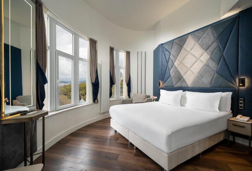 Schlafzimmer mit einem großen weißen Bett und Fenstern in der Unterkunft Adamar Hotel-Special Category in Istanbul