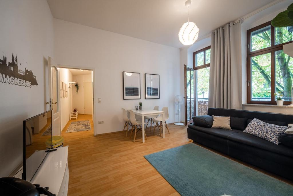 ein Wohnzimmer mit einem Sofa und einem Tisch in der Unterkunft Große Altstadtwohnung im Zentrum, mit Balkon, TOP Lage, 4 Schlafplätzen in Magdeburg