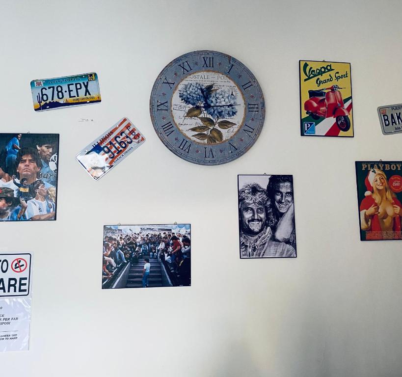 un mur avec une horloge et des photos sur lui dans l'établissement Dama HostelBB, à Naples