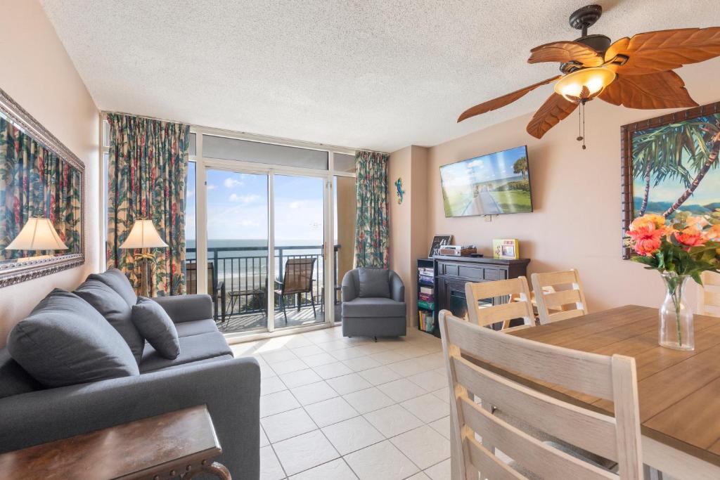 a living room and dining room with a table and a couch at Atlantica Towers Condo w Balcony by Hosteeva in Myrtle Beach