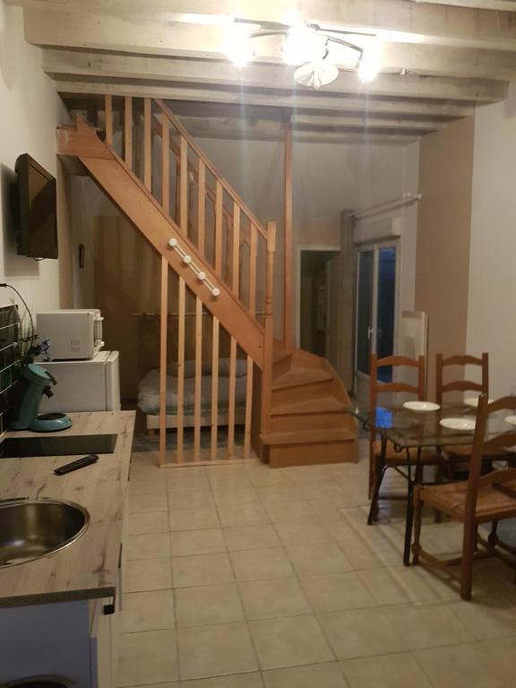 a kitchen with a staircase and a table and chairs at Le Betrot in Estissac