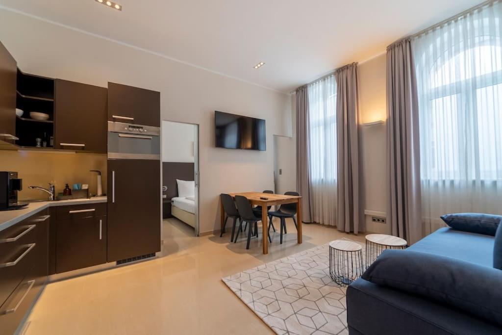 uma sala de estar com um sofá e uma cozinha com uma mesa em Levestate Apartments Klährgasse Vol 2 em Viena