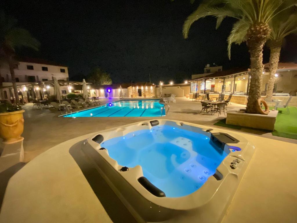 uma piscina à noite com uma banheira de hidromassagem em Bab Al Shams Resort em Jericó