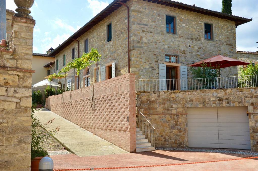 a brick house with a garage and an umbrella at I Casaloni in Panzano