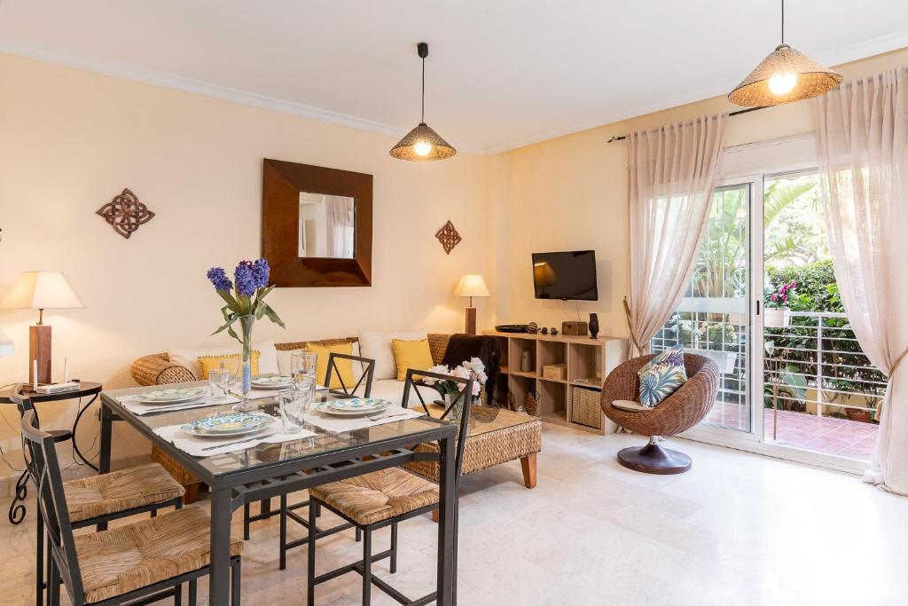 een woonkamer met een tafel en stoelen en een bank bij BLONZU SAFARi in Benalmádena