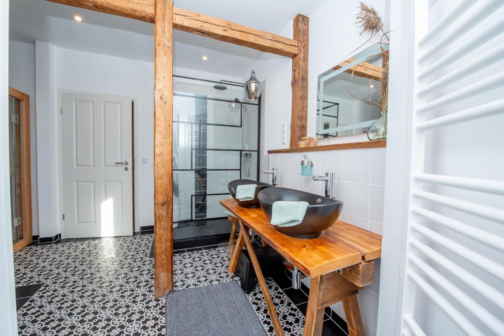 艾森納赫的住宿－Apartment Kronprinz zentral mit Infrarot-Sauna，木桌上配有黑色水槽的浴室