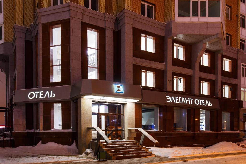 a apartment building with a sign on the front of it at Elegant Hotel in Tomsk