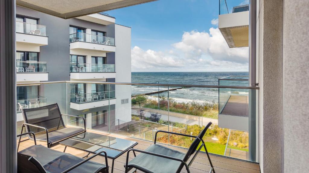 einen Balkon mit Stühlen und Meerblick in der Unterkunft Apartamenty Sun & Snow Przy plaży in Mielno