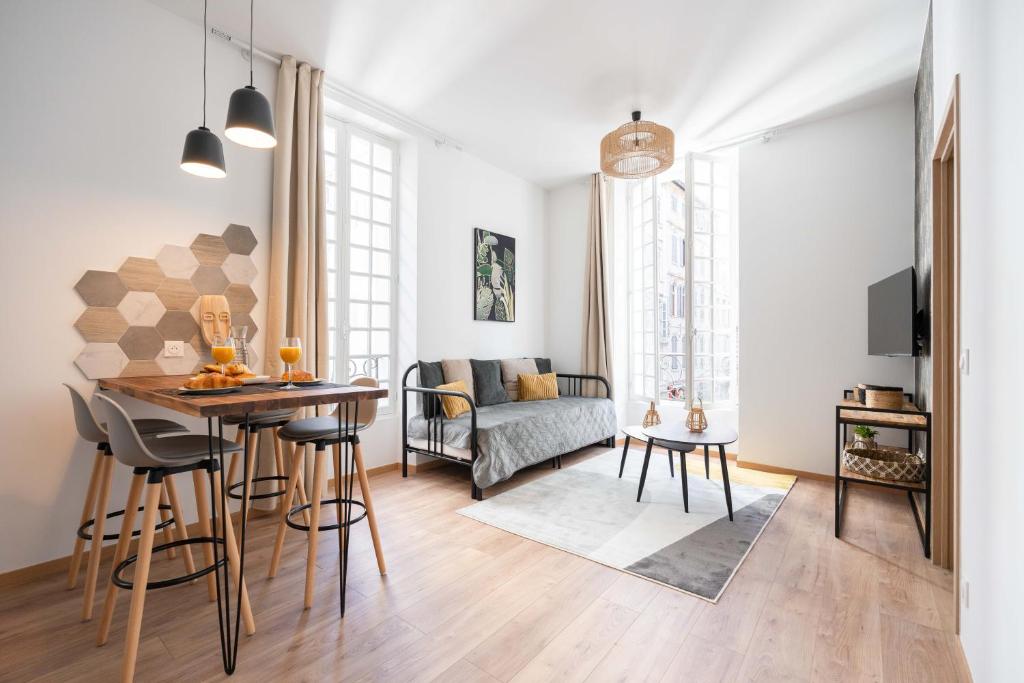 a living room with a table and a couch at Les Petits Pavillons Appartements Standing 1 chambre 4 pers Clim Vieux-Port in Marseille