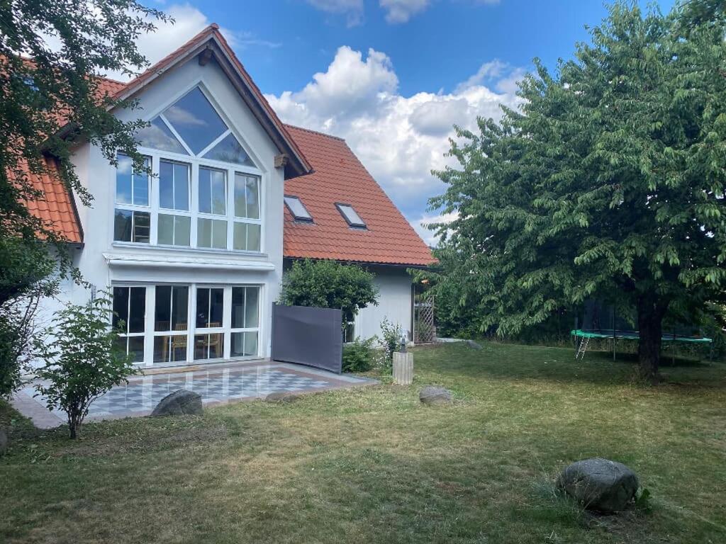 een wit huis met een bank in een tuin bij Ferienwohnung Villa Hygge in Mitterteich