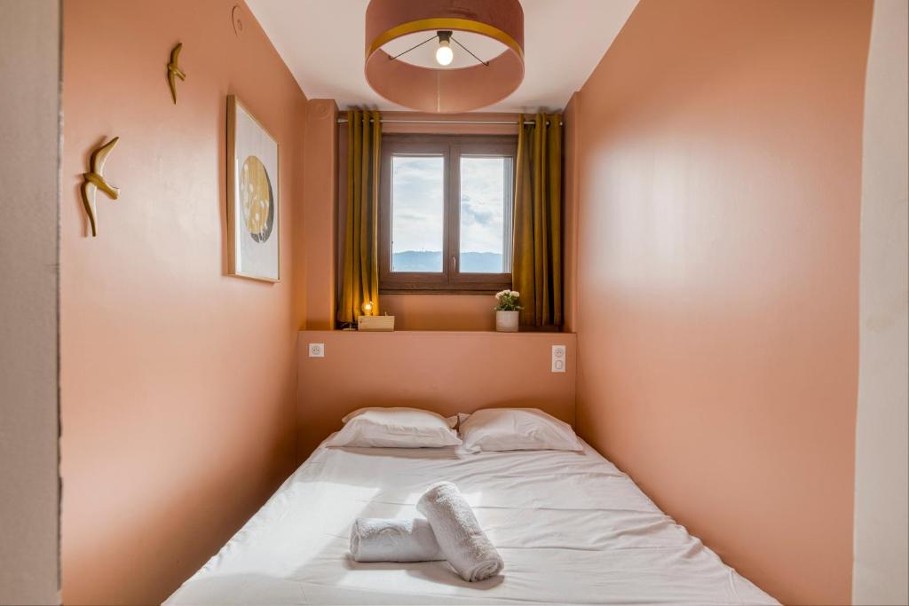 a small bed in a room with a window at Le Bouvard - MyCosyApart, Central Gare 100m, Netflix in Annecy