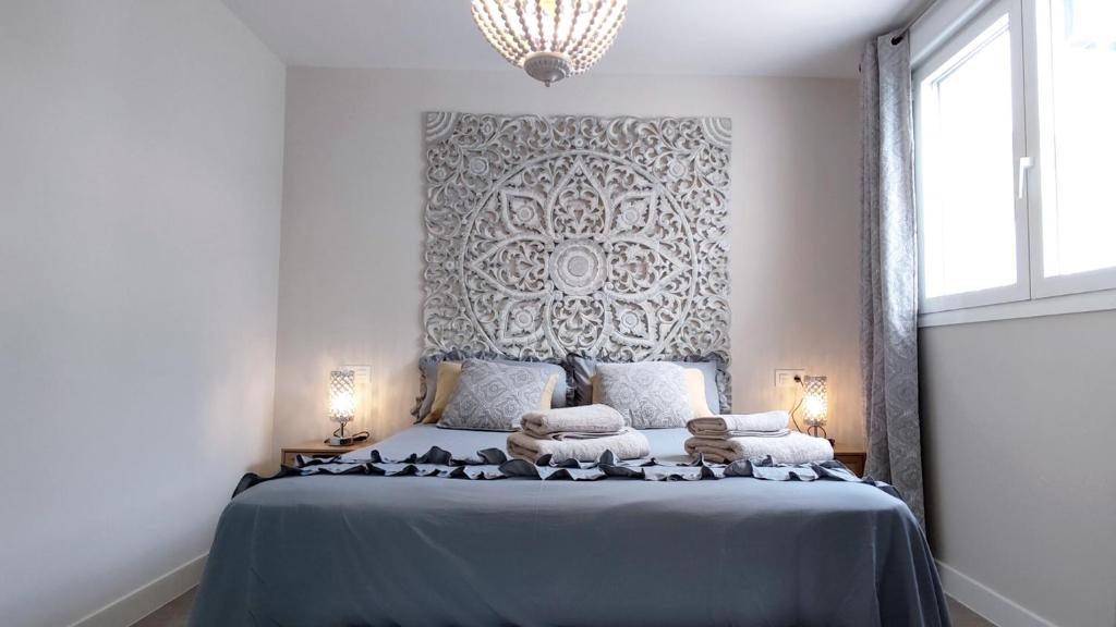 a bedroom with a blue bed with towels on it at Dunas Beach II Apartment in Torrox Costa