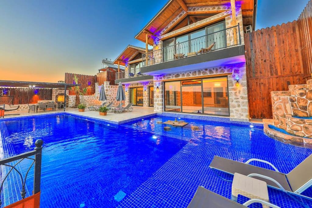 a large swimming pool in front of a house at Patara'da 3 Yatak Odalı Deniz Manzaralı Lüks Villa in Gelemiş