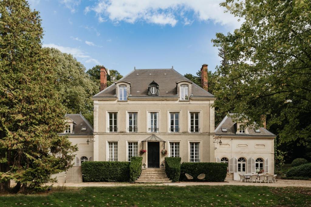 a large white house with a staircase in front at Manoir François du Tilleul - Reims - Fismes in Fismes