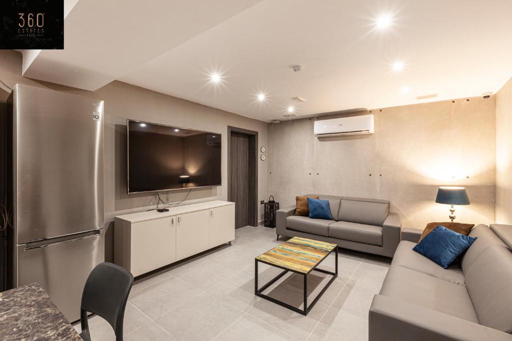 Il comprend un salon doté d'un canapé et d'une télévision à écran plat. dans l'établissement Modern, Large and Spacious HOME, Perfect for GROUP by 360 Estates, à Msida