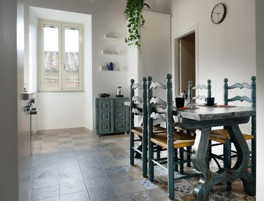 uma sala de jantar com uma mesa de madeira e cadeiras em Casa Gli Olmi - centro storico em Bracciano