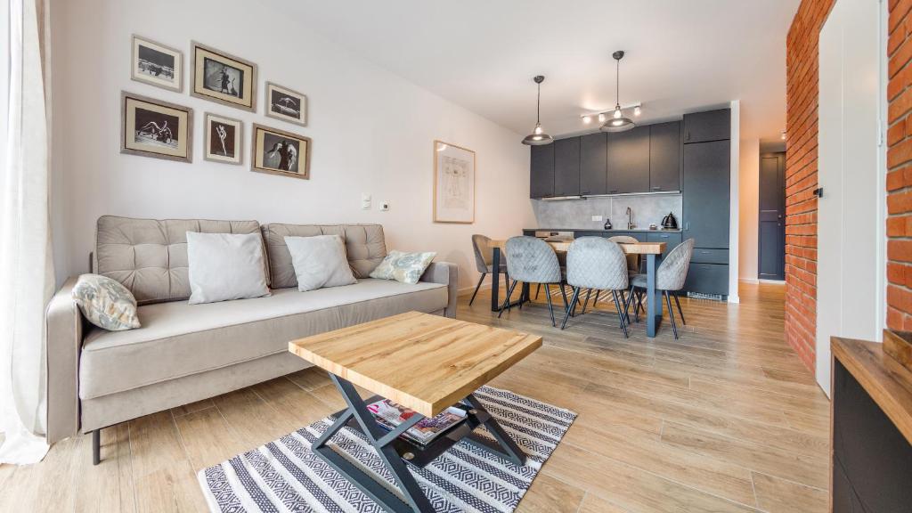 a living room with a couch and a table at Bursztynowe Osiedle Jantar, Sun & Snow in Jantar