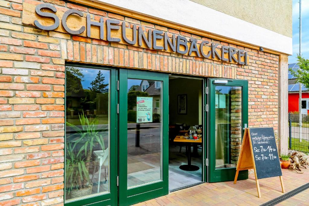 un edificio de ladrillo con un letrero para un restaurante en Scheunenbäckerei Usedom, Ostseebad Trassenheide en Trassenheide