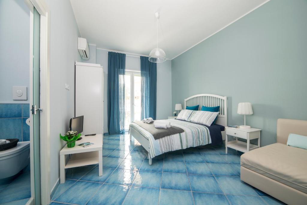 a blue bedroom with a bed and a bathroom at CAPRI B&B in Salerno